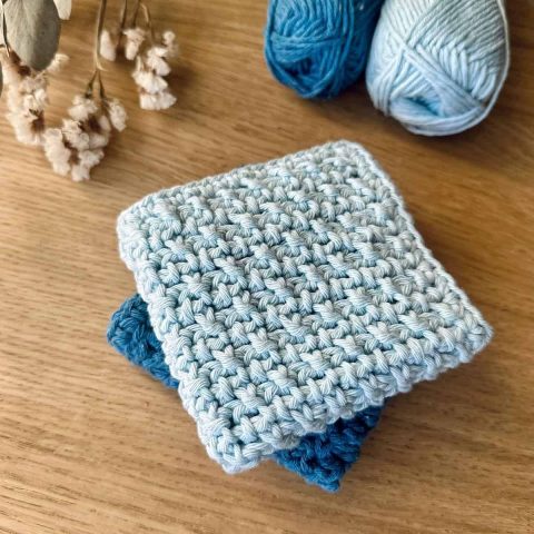 2 blue crochet dishcloths on table
